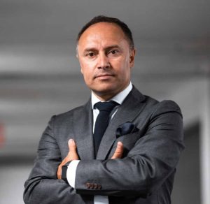 A man in a suit and tie with his arms crossed.
