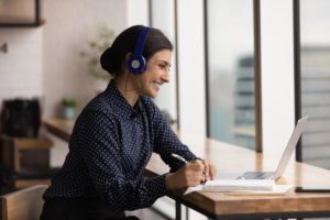 A woman wearing headphones sitting at a table.